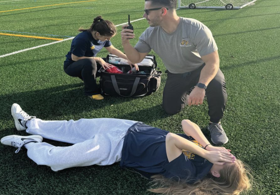 On the sidelines: Athletic trainer Josh Rivera coaches student Grace Urun '26 on how to wrap a twisted ankle.